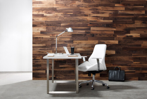 A modern workspace featuring a white desk and chair against a rustic wooden wall, complemented by a sleek desk lamp and accessories.