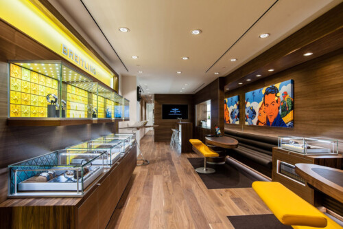 A modern boutique interior showcasing display cases, wooden accents, and artwork, creating an inviting atmosphere for customers.